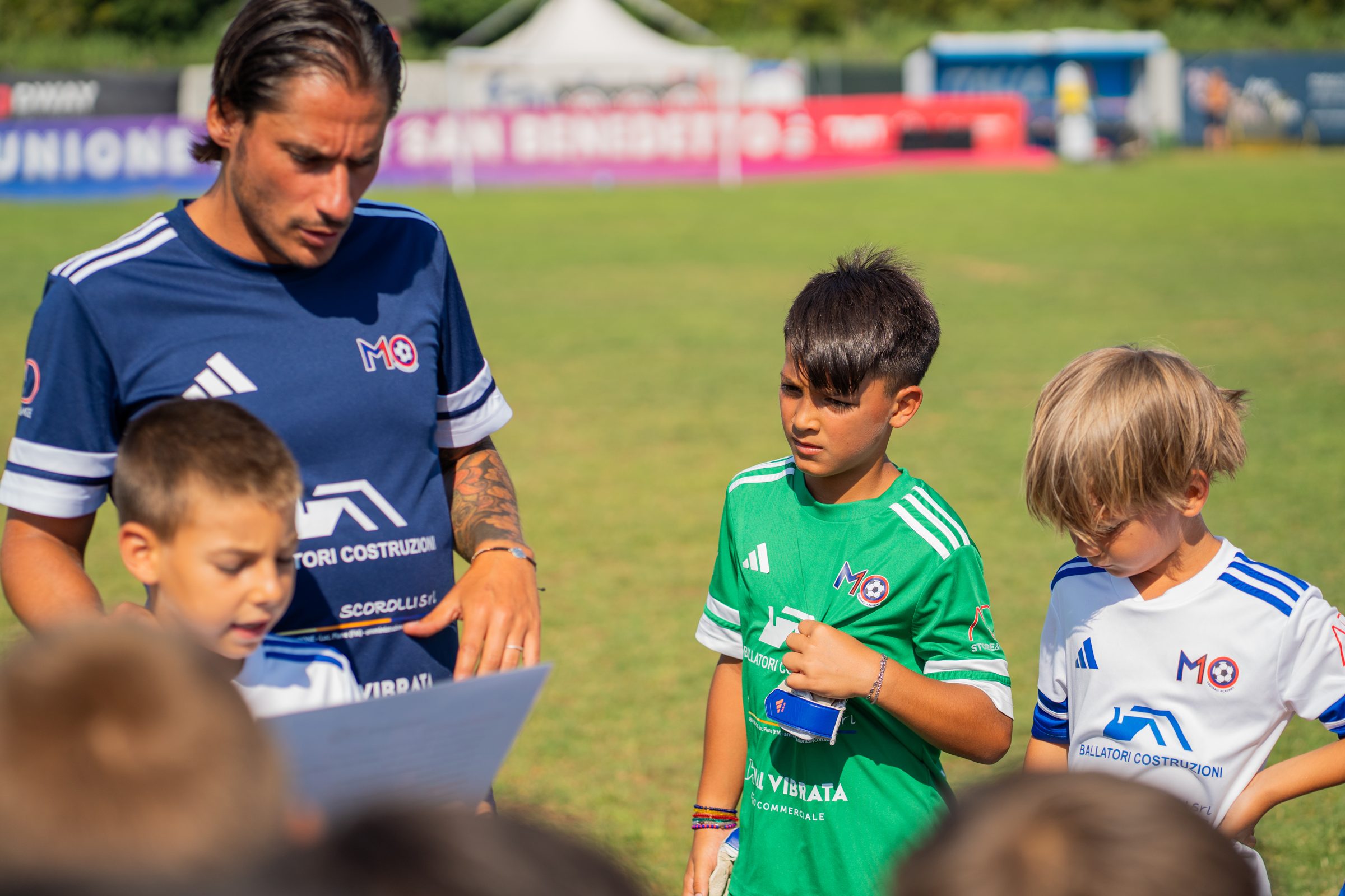 Un coach M10 spiega l'esercizio ai ragazzi del camp 2026