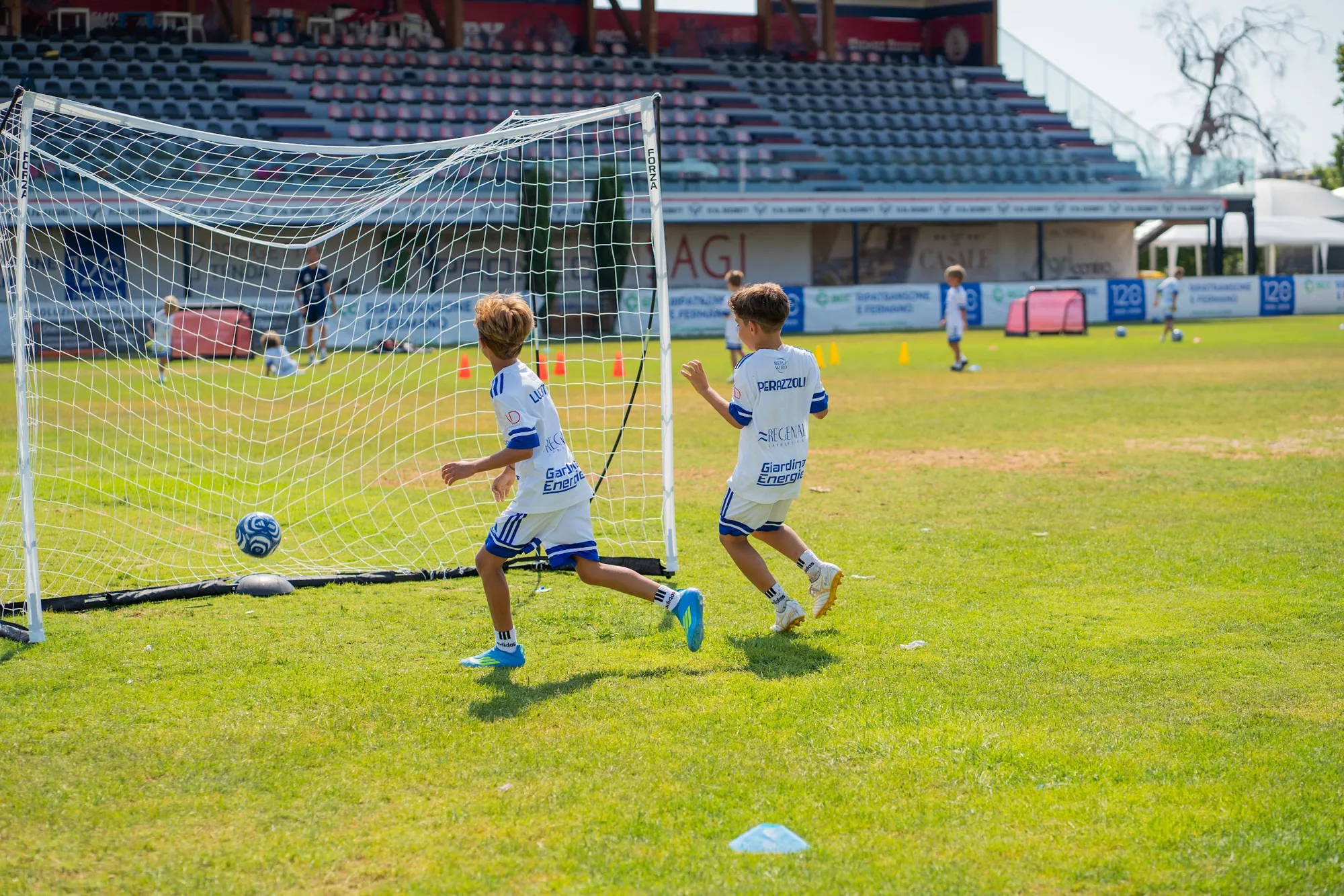 Ragazzi del Summer Camp M10 2026 davanti ai banner dei partner
