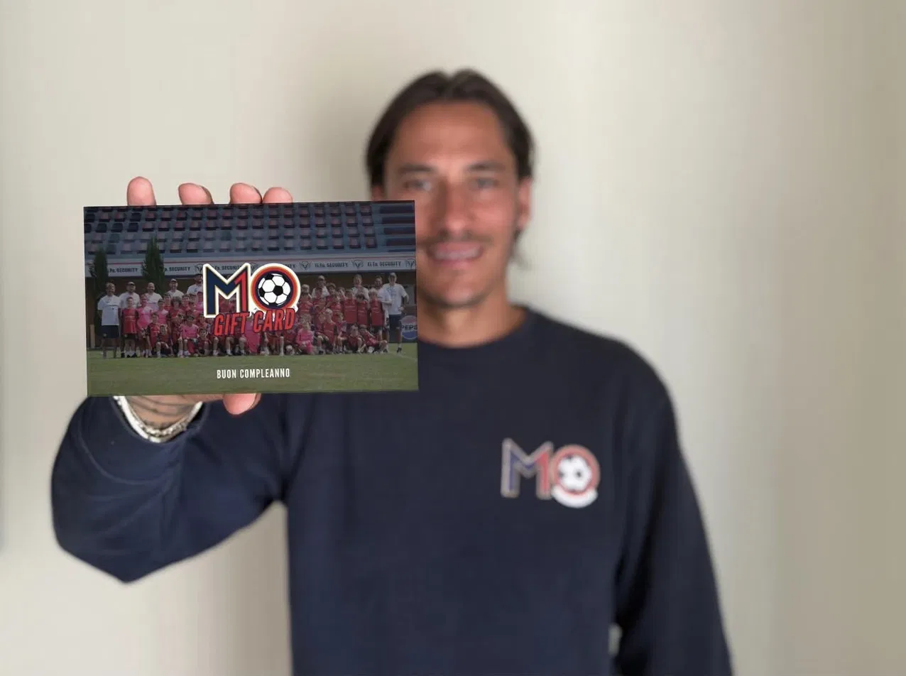 Mario Titone mostra la M10 Gift Card fisica firmata dallo staff